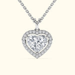 Heart-shaped diamond pendant on a silver chain, surrounded by smaller diamonds.