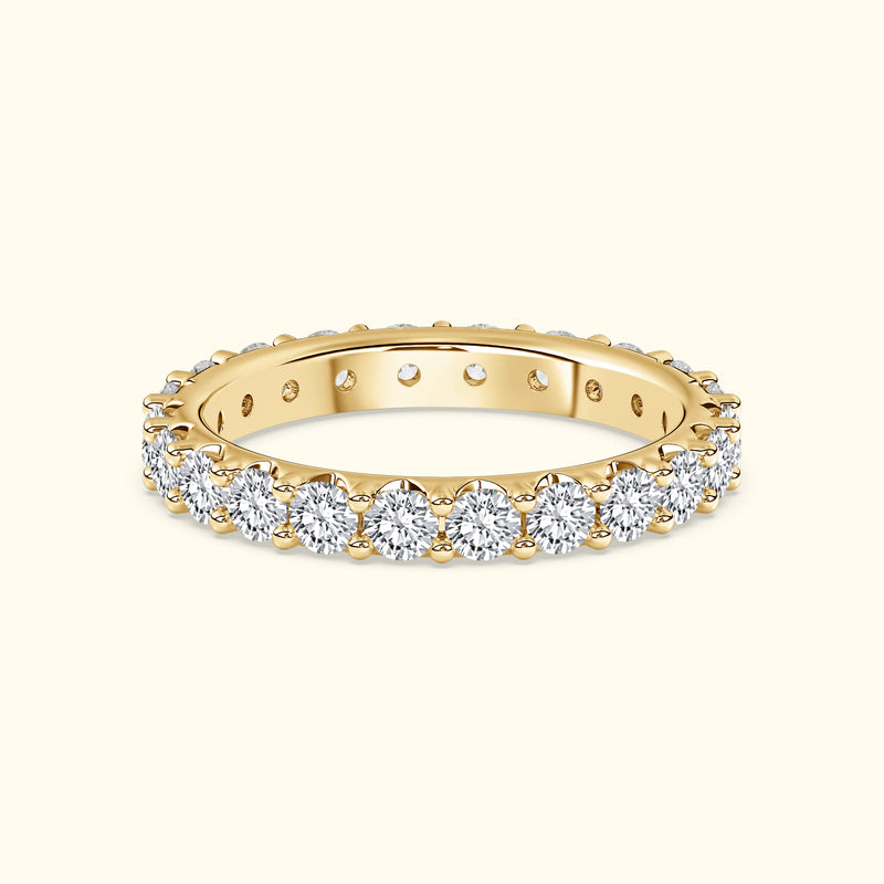 Gold band ring adorned with shimmering round diamonds around the entire circle.