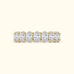 Gold band ring with multiple oval-shaped diamonds set in a delicate arrangement.
