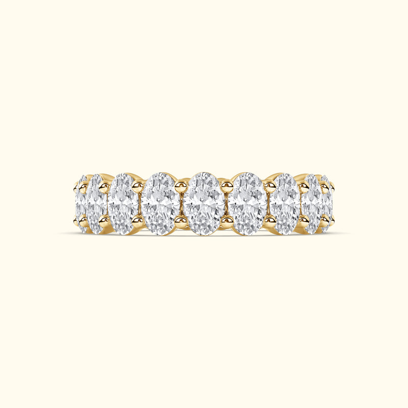 Gold band ring with multiple oval-shaped diamonds set in a delicate arrangement.