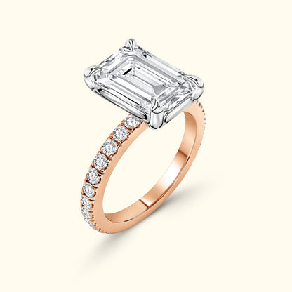 Elegant rose gold ring featuring a large emerald-cut diamond and smaller pave-set diamonds.