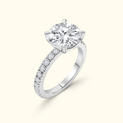 A sparkling solitaire diamond ring with a pave band in white gold.