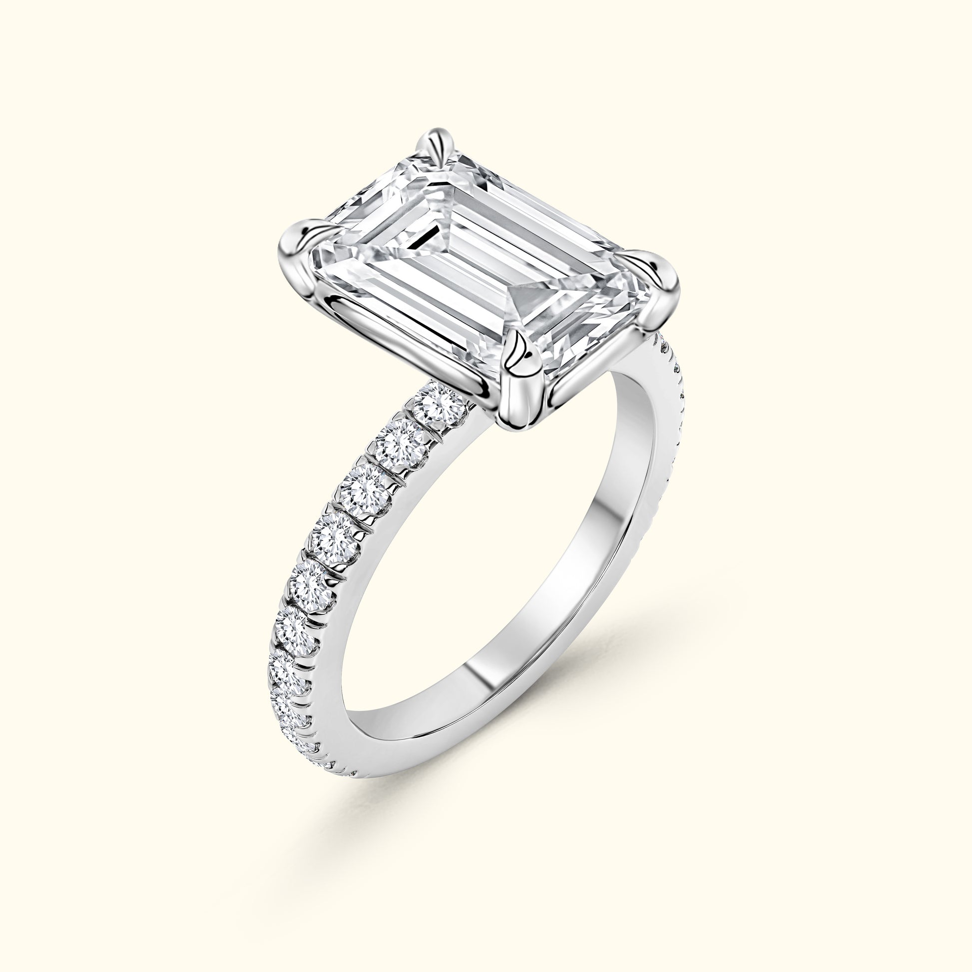 Elegant diamond engagement ring with an emerald-cut center stone and a pave band.