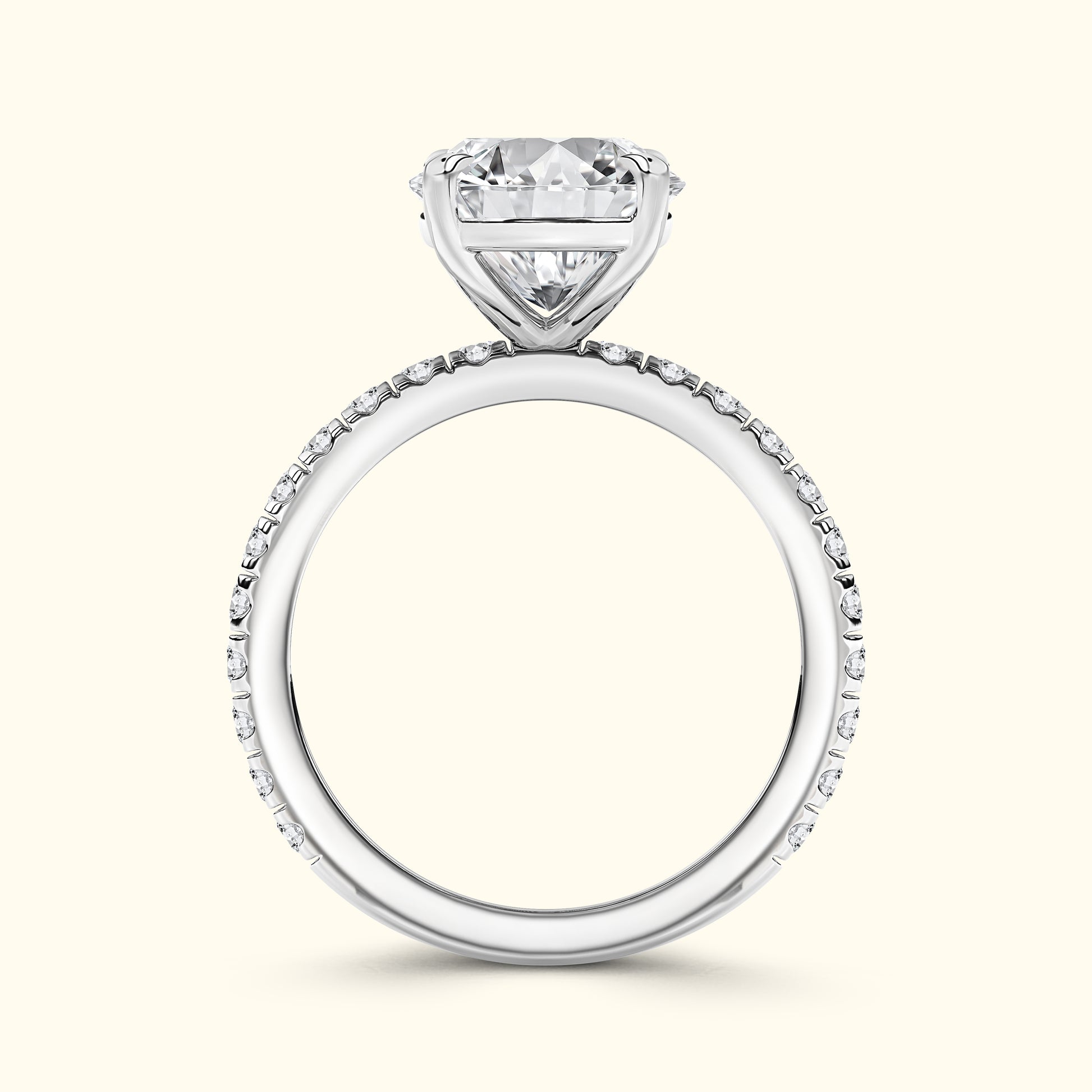 Solitaire diamond ring with a heart-shaped stone and pavé band in white gold.