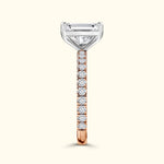 Elegant diamond engagement ring with a rose gold band and a central emerald-cut stone.