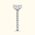 Elegant diamond ring with a central emerald-cut stone and a pave-set band.