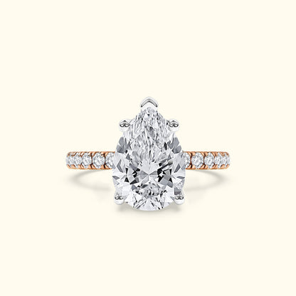 Pear-shaped diamond ring with a rose gold band and small sparkling accents.