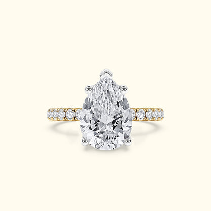 Stunning pear-shaped diamond ring with a gold band and smaller diamonds along the shank.