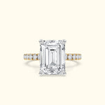Elegant emerald-cut diamond ring with a gold band and sparkling side stones.