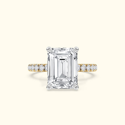 Elegant emerald-cut diamond ring with a gold band and sparkling side stones.