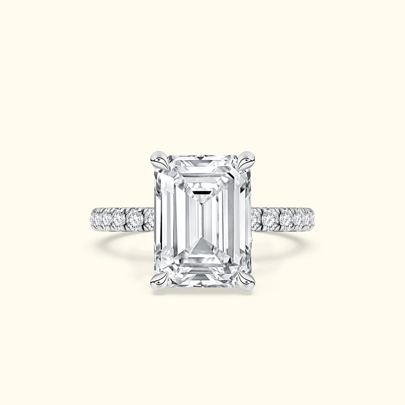 Elegant emerald-cut diamond ring with a delicate pavé band.