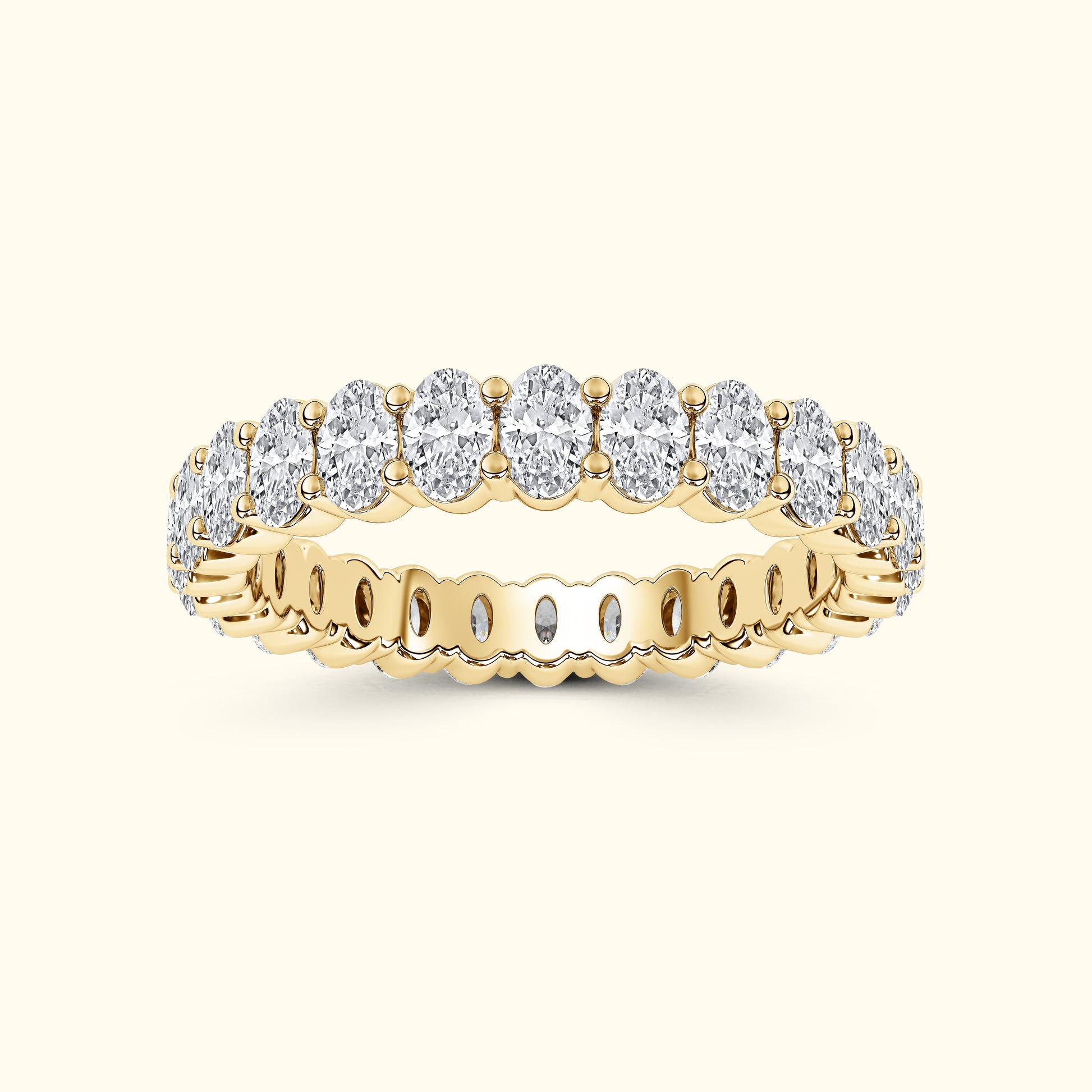 Gold band ring featuring a series of oval diamonds set in a row.