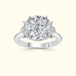 Three-stone diamond ring featuring a large center stone and two smaller side stones.