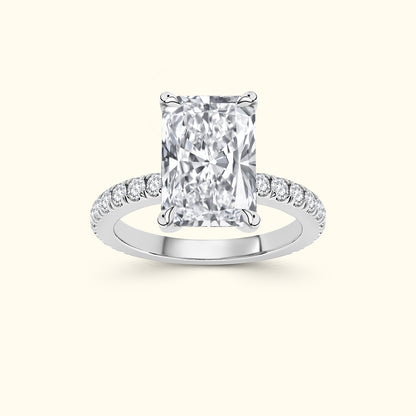 Rectangular diamond engagement ring with a pave band. Set on a light background.