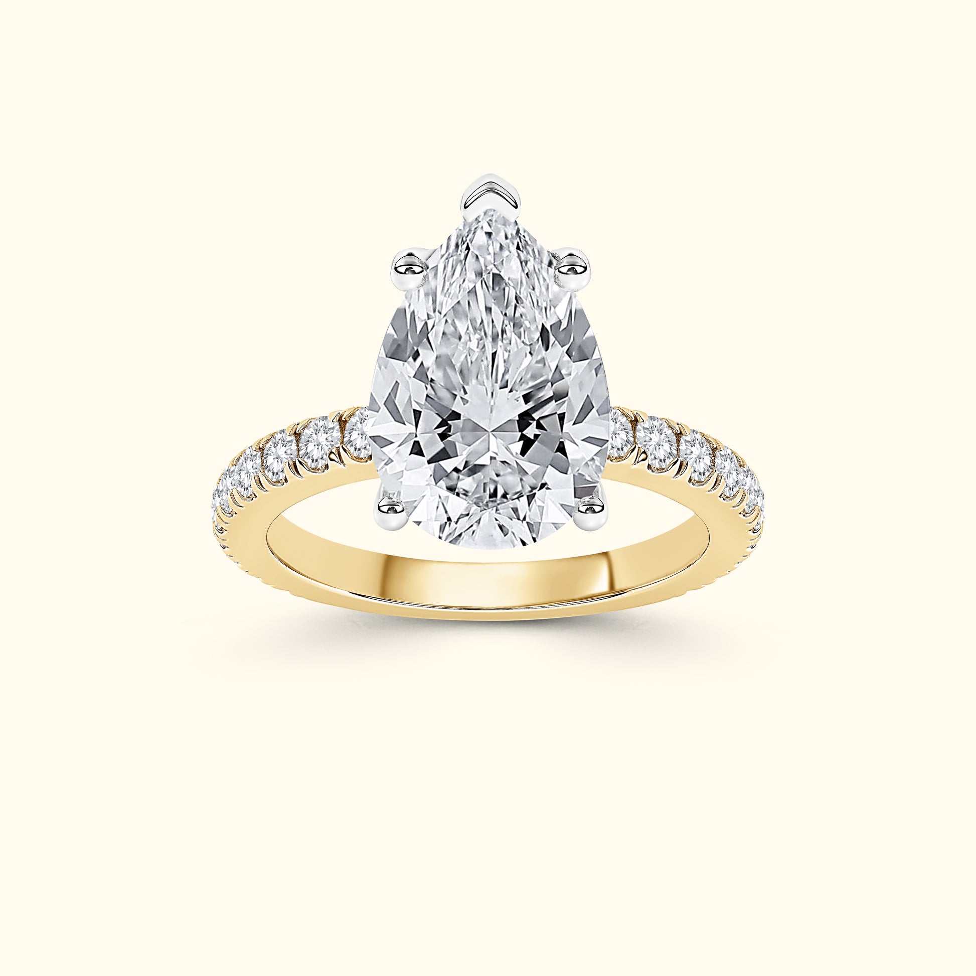 Gold engagement ring with a pear-shaped diamond and smaller side diamonds on the band.