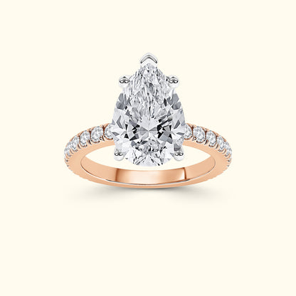 Pear-shaped diamond ring with a rose gold band and smaller diamonds along the sides.