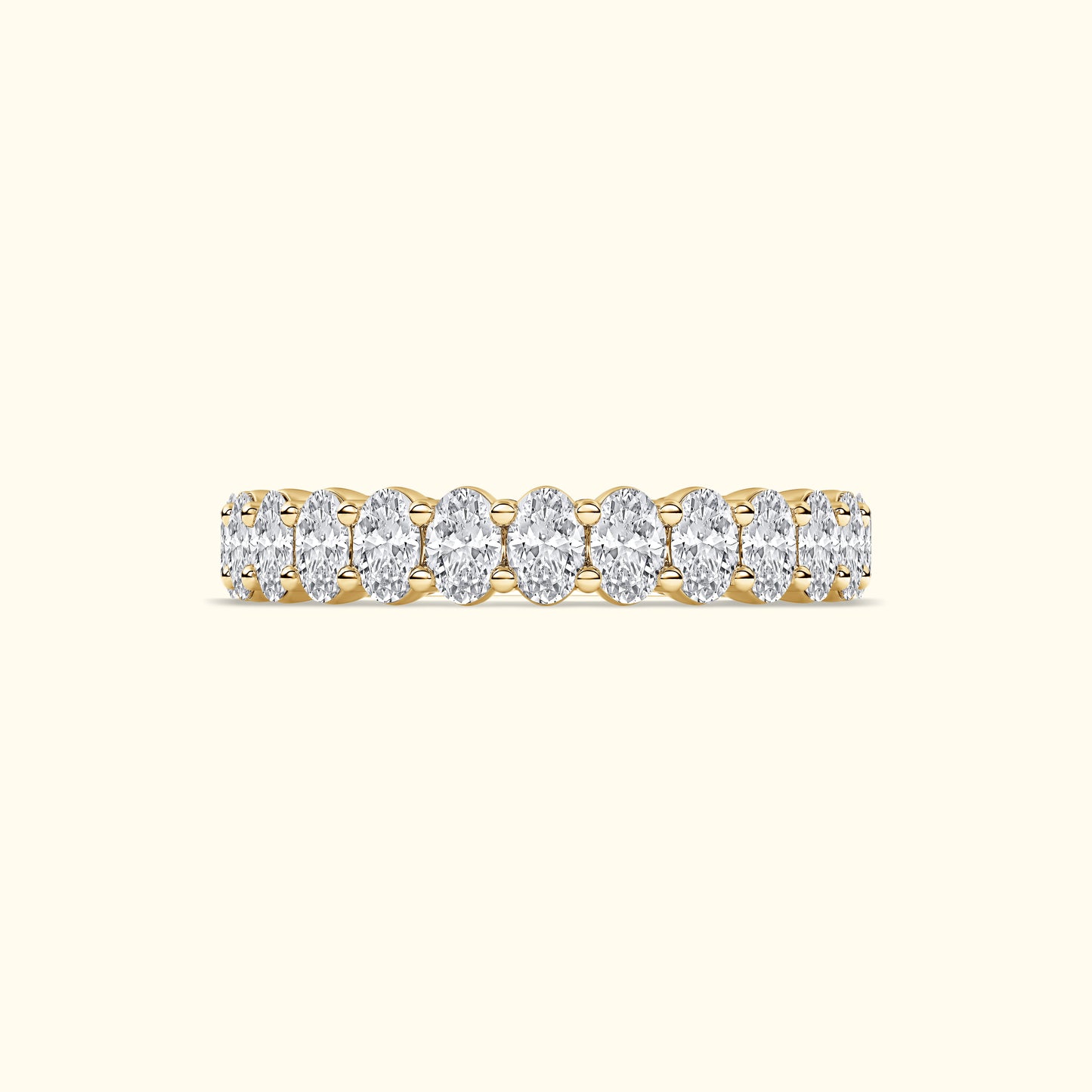 Golden band ring adorned with oval diamonds arranged in a row.