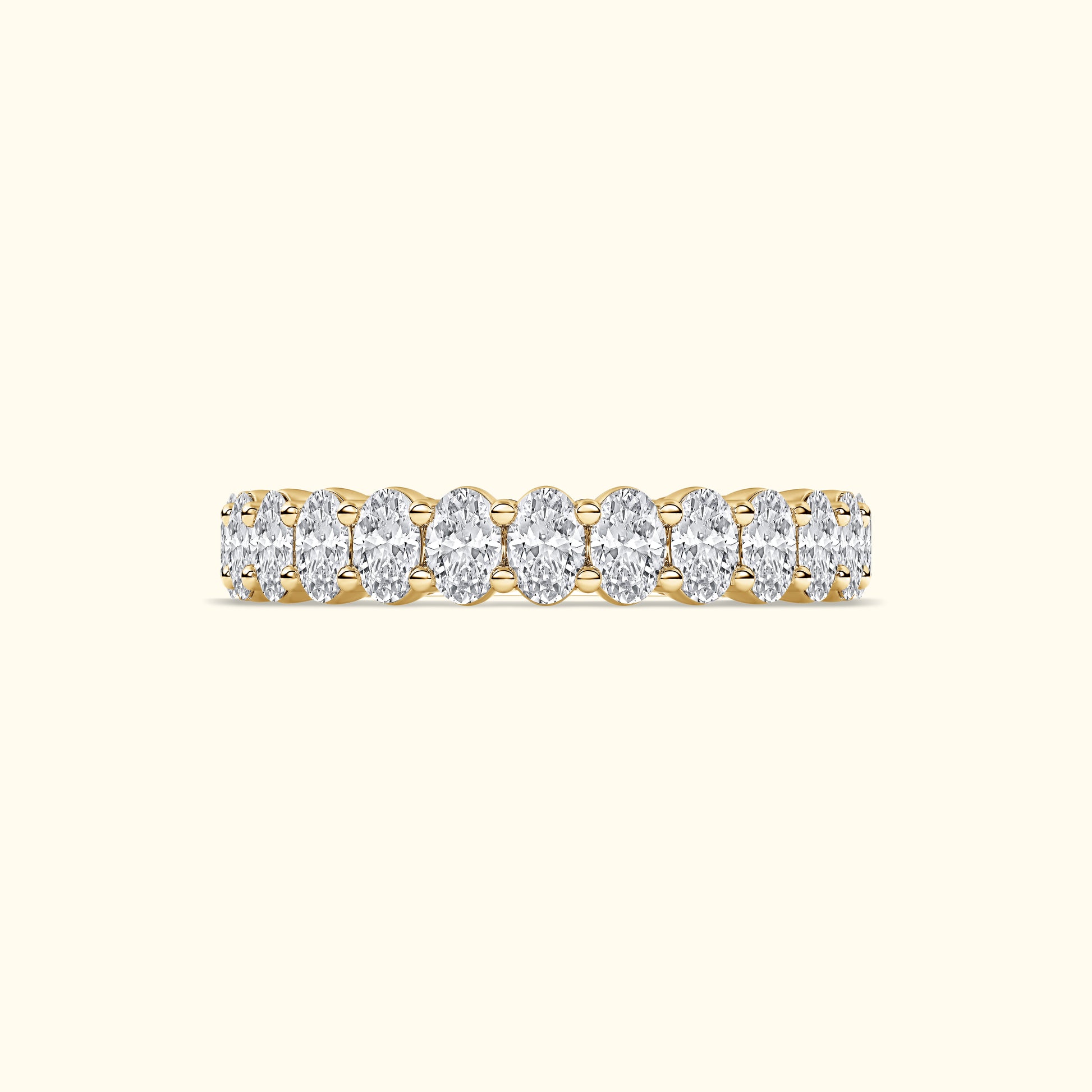 Golden band ring adorned with oval diamonds arranged in a row.