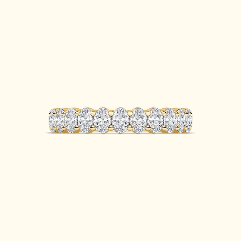 Golden band ring adorned with oval diamonds arranged in a row.