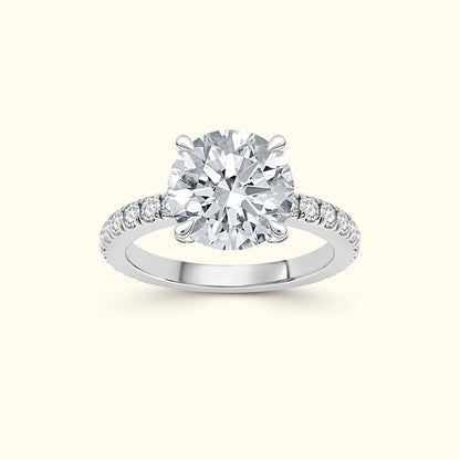 A solitaire diamond ring with a round center stone and smaller diamonds on the band.