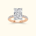 Rectangular diamond ring with small side diamonds on a rose gold band.