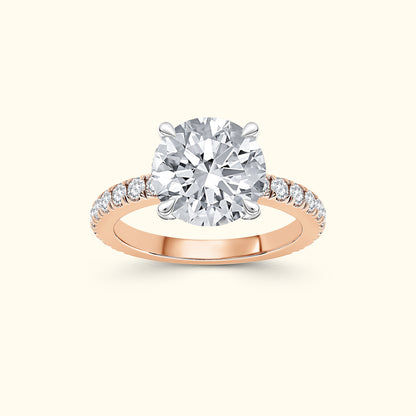 Rose gold engagement ring featuring a large round diamond and smaller diamonds along the band.