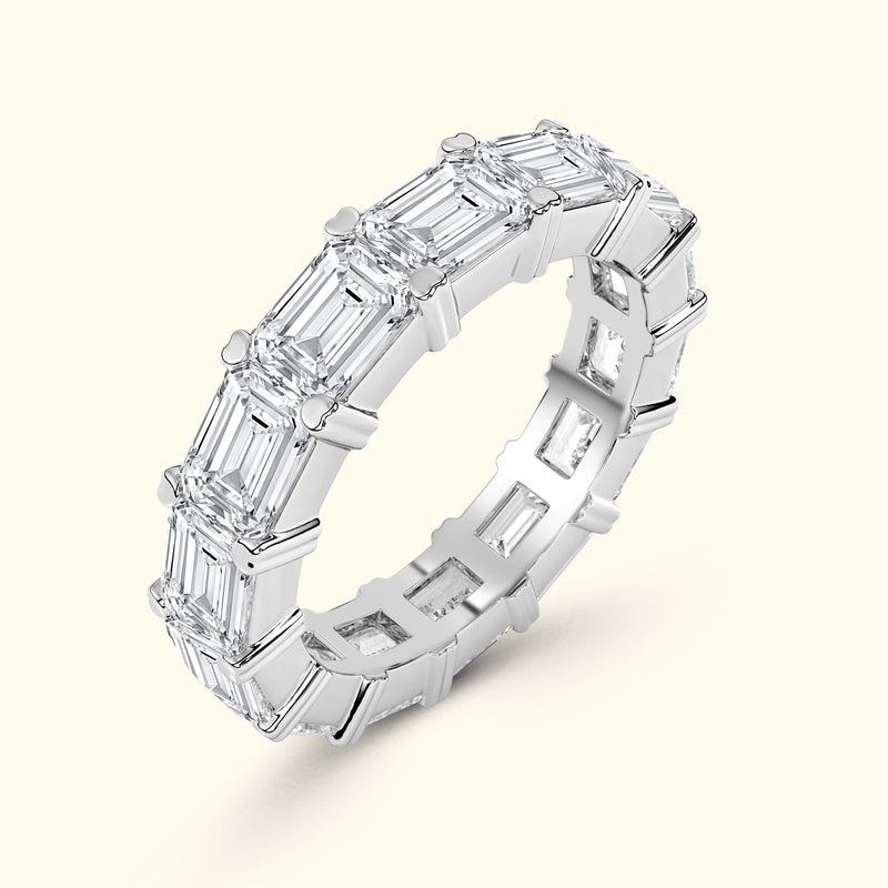 Elegant silver ring featuring a series of emerald-cut diamonds arranged in a band.