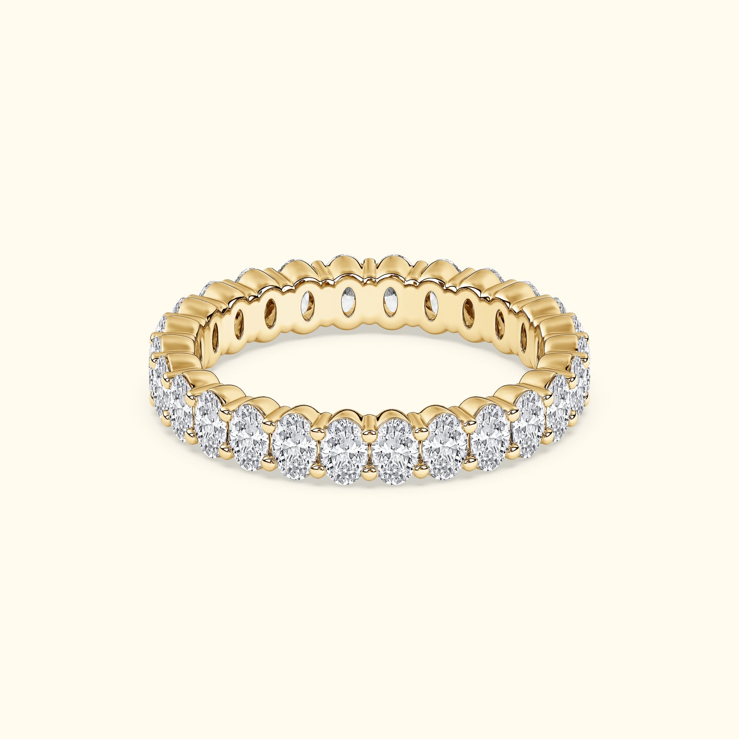 Gold band ring adorned with sparkling oval diamonds, set against a light background.