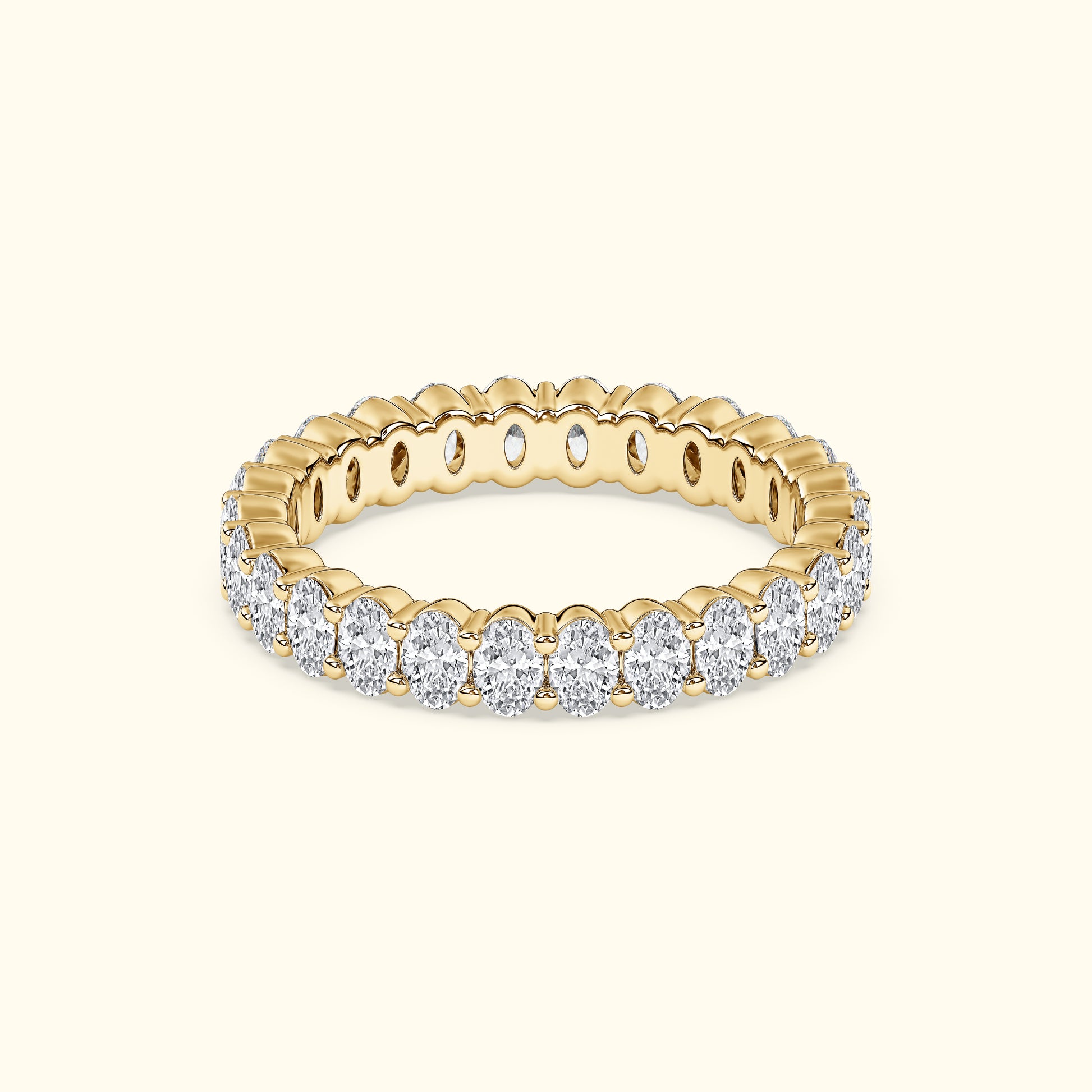 Gold band ring adorned with sparkling oval diamonds, set against a light background.