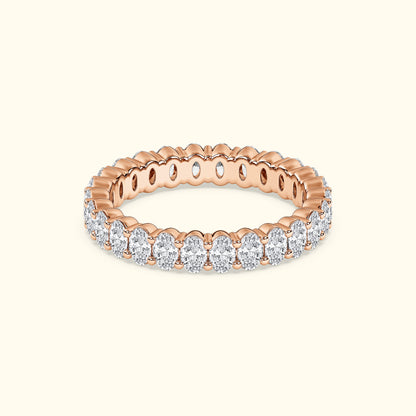 Rose gold ring adorned with sparkling oval diamonds, showcasing a scalloped design.