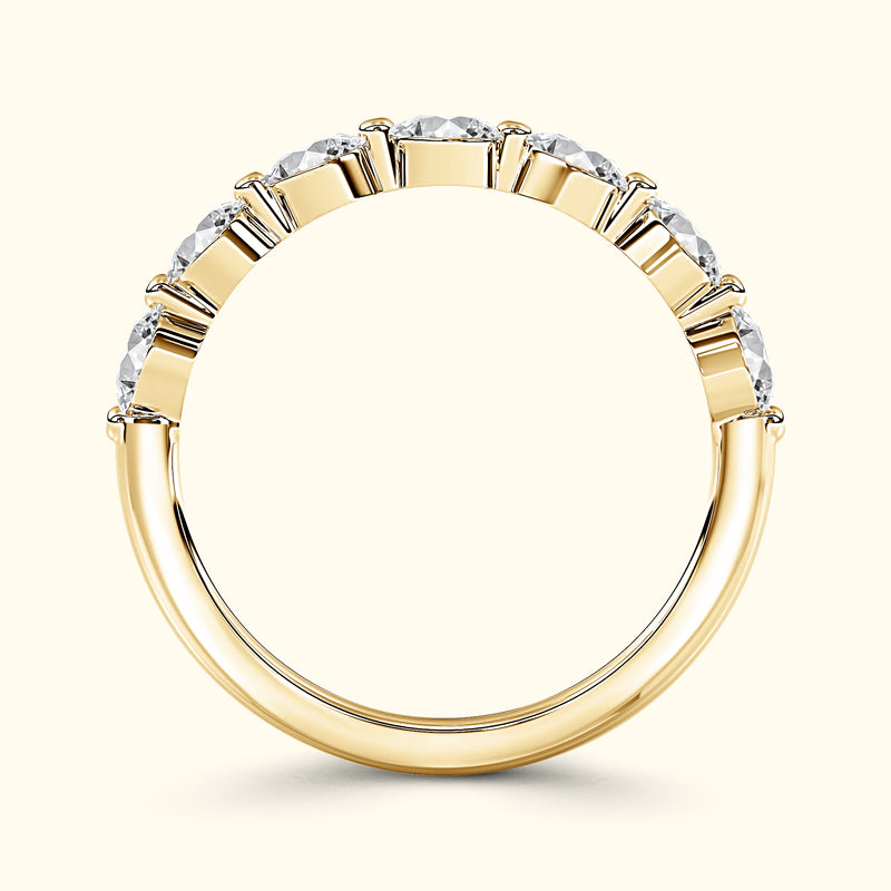 Gold band ring set with alternating round and rectangular diamonds.