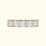 Elegant gold band set with alternating emerald-cut diamonds.