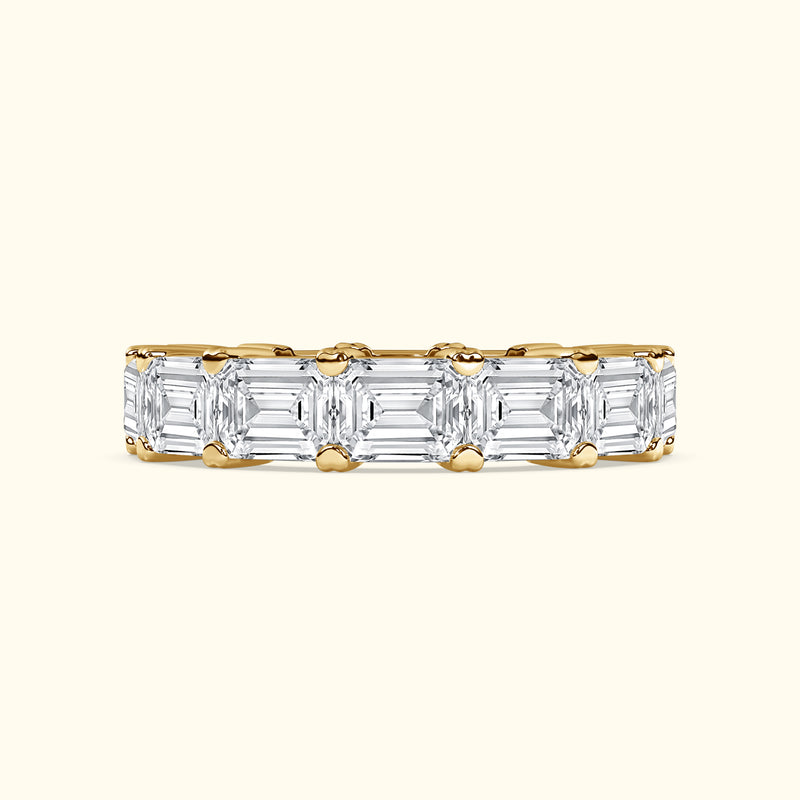 Elegant gold band set with alternating emerald-cut diamonds.