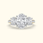 Three-stone diamond ring featuring a central oval diamond and two round diamonds on the side.