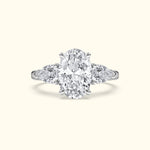 Elegant three-stone engagement ring featuring a large oval diamond flanked by two pear-shaped diamonds.