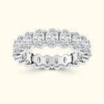 A silver band ring set with multiple oval-cut diamonds in a continuous circle.