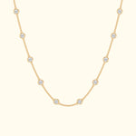 Delicate gold necklace featuring evenly spaced circular diamond accents.