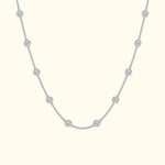 Delicate silver necklace with circular diamond accents evenly spaced along the chain.