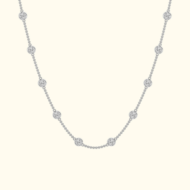Delicate silver necklace with circular diamond accents evenly spaced along the chain.