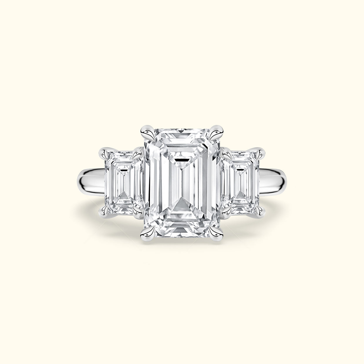Elegant three-stone ring featuring an emerald-cut center diamond with two smaller side diamonds.