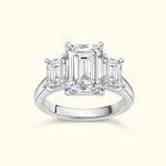Three-stone emerald cut diamond ring on a polished band.