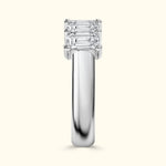 Three-stone diamond ring with a sleek silver band, reflecting light beautifully.