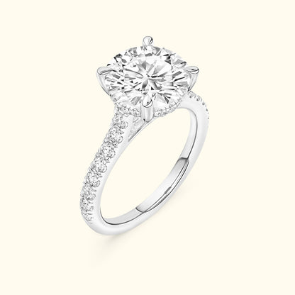 Elegant solitaire diamond engagement ring with a round center stone and pave setting.