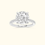 Round diamond engagement ring with a delicate band and sparkling accents.