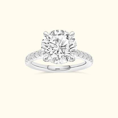 Round diamond engagement ring with a delicate band and sparkling accents.