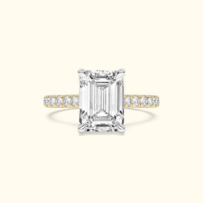 Emma-shaped diamond ring with a gold and silver band adorned with smaller diamonds.