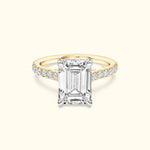Elegant engagement ring featuring an emerald-cut diamond and a delicate band with smaller diamonds.