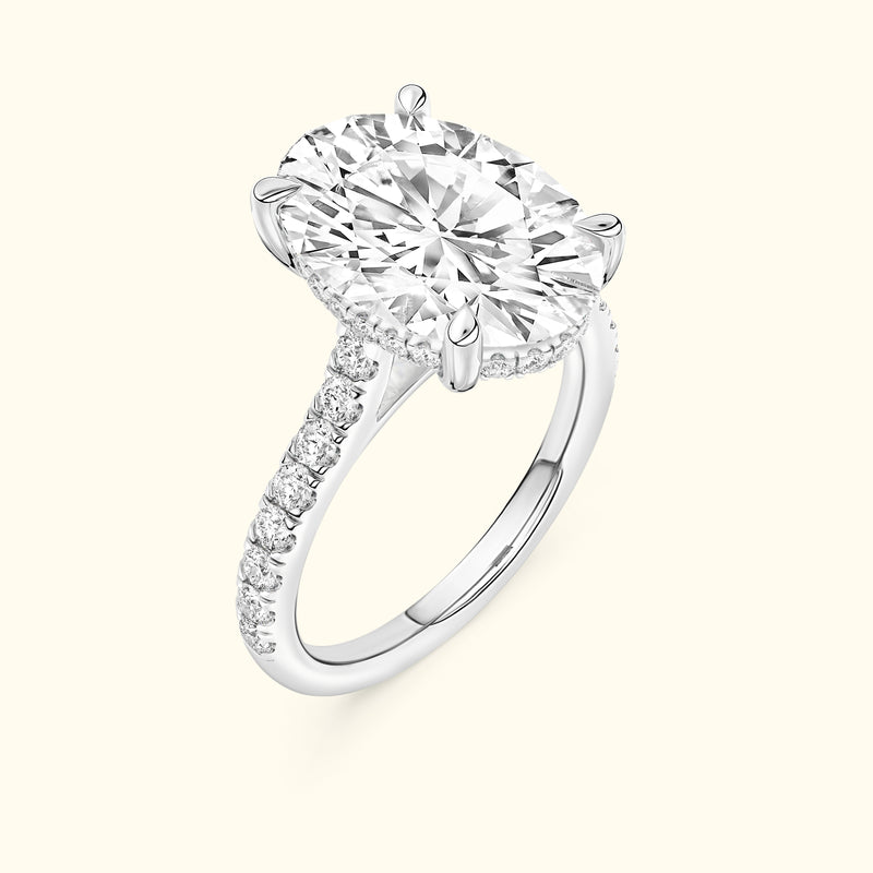 Brilliant oval-cut diamond engagement ring with a sparkling band of smaller diamonds.