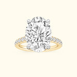 Oval diamond engagement ring with a gold band and smaller diamonds along the shank.