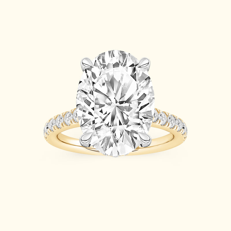 Oval diamond engagement ring with a gold band and smaller diamonds along the shank.